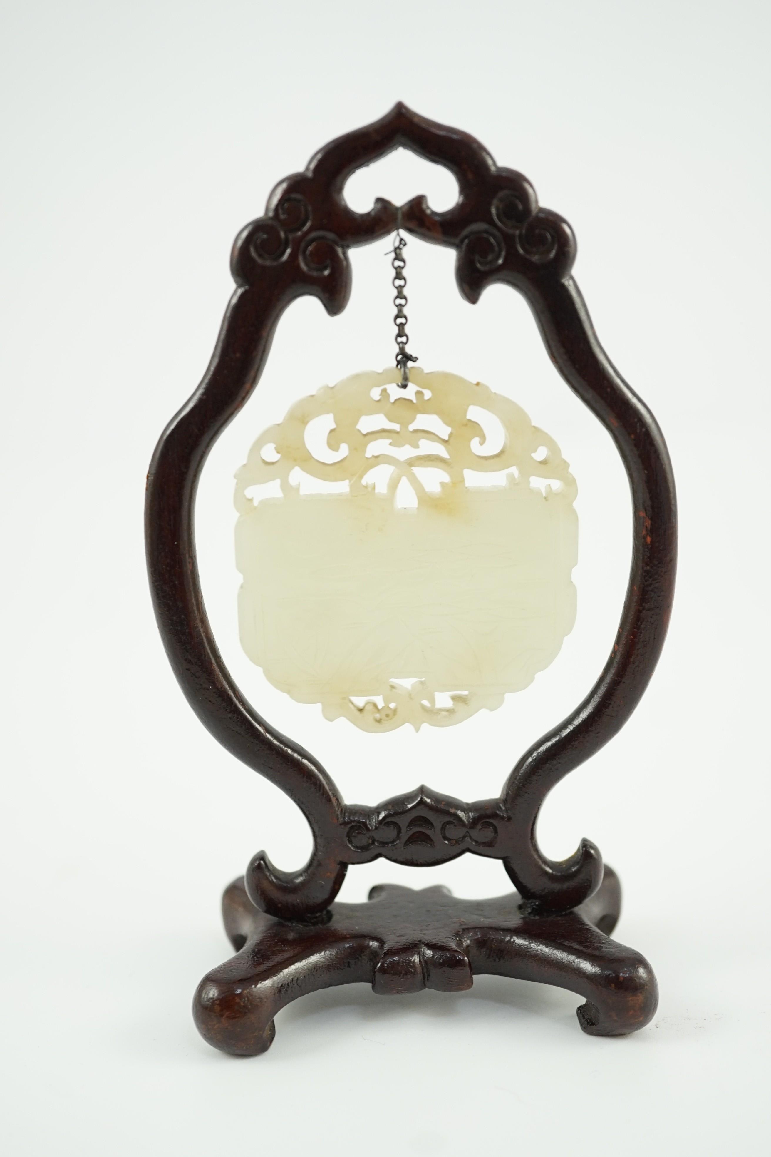 A Chinese pale celadon jade inscribed plaque, 19th/20th century, 5.1cm, suspended from a wood stand